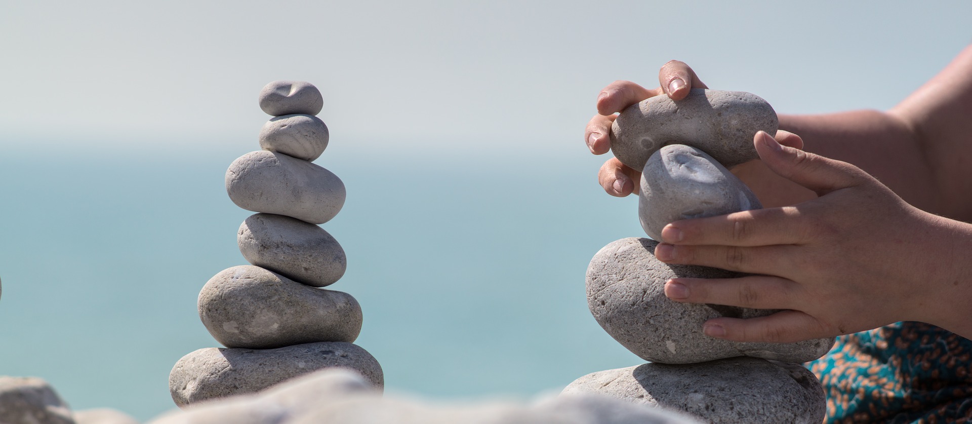 Person arranging stacks of flat rocks